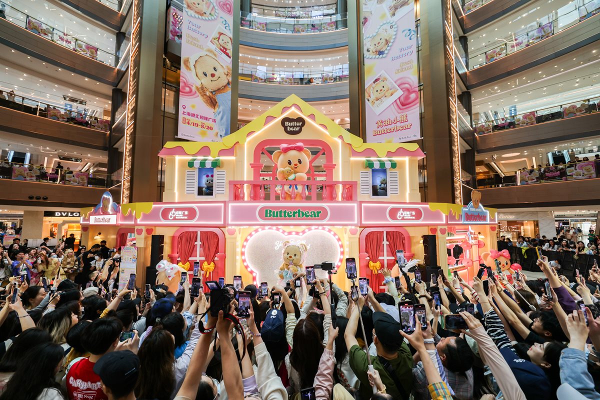Ativação ButterBear no átrio do Grand Gateway 66, em Shanghai, cercada por visitantes registrando a instalação.